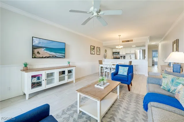a living room with furniture a table and kitchen view