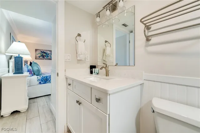 a bathroom with a sink vanity mirror and toilet