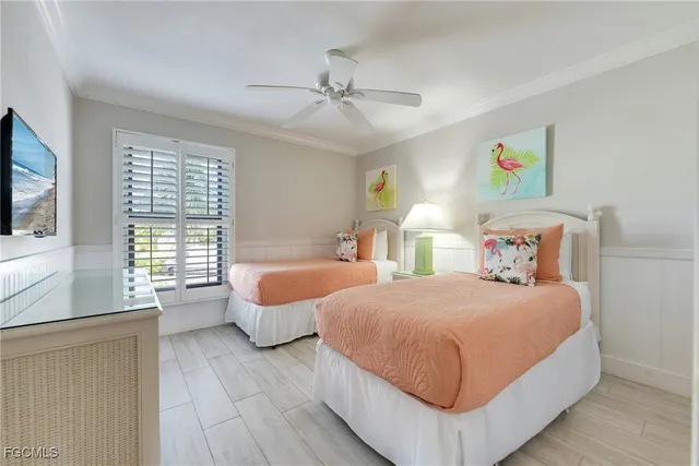 a bedroom with two beds and a large window