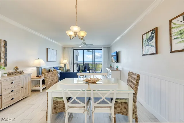 a view of a dining room with furniture a chandelier and wooden floor