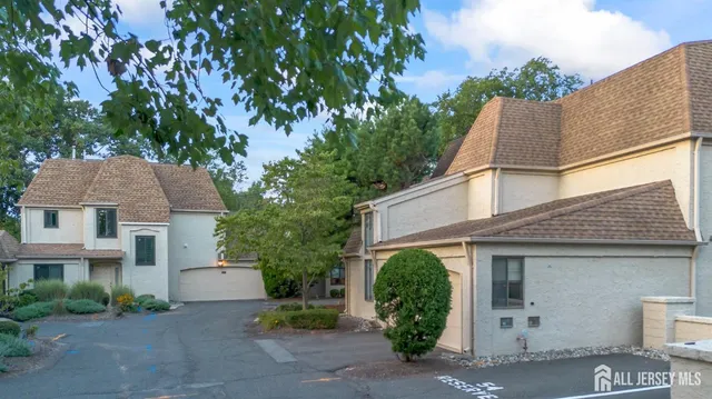 a view of a white house next to a yard