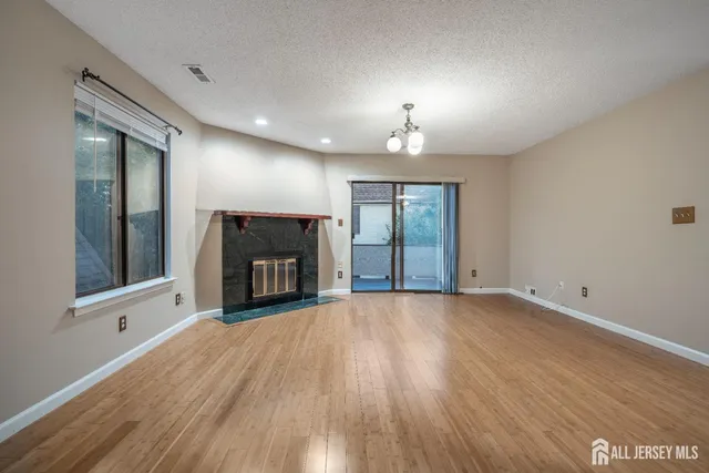 an empty room with windows and fireplace
