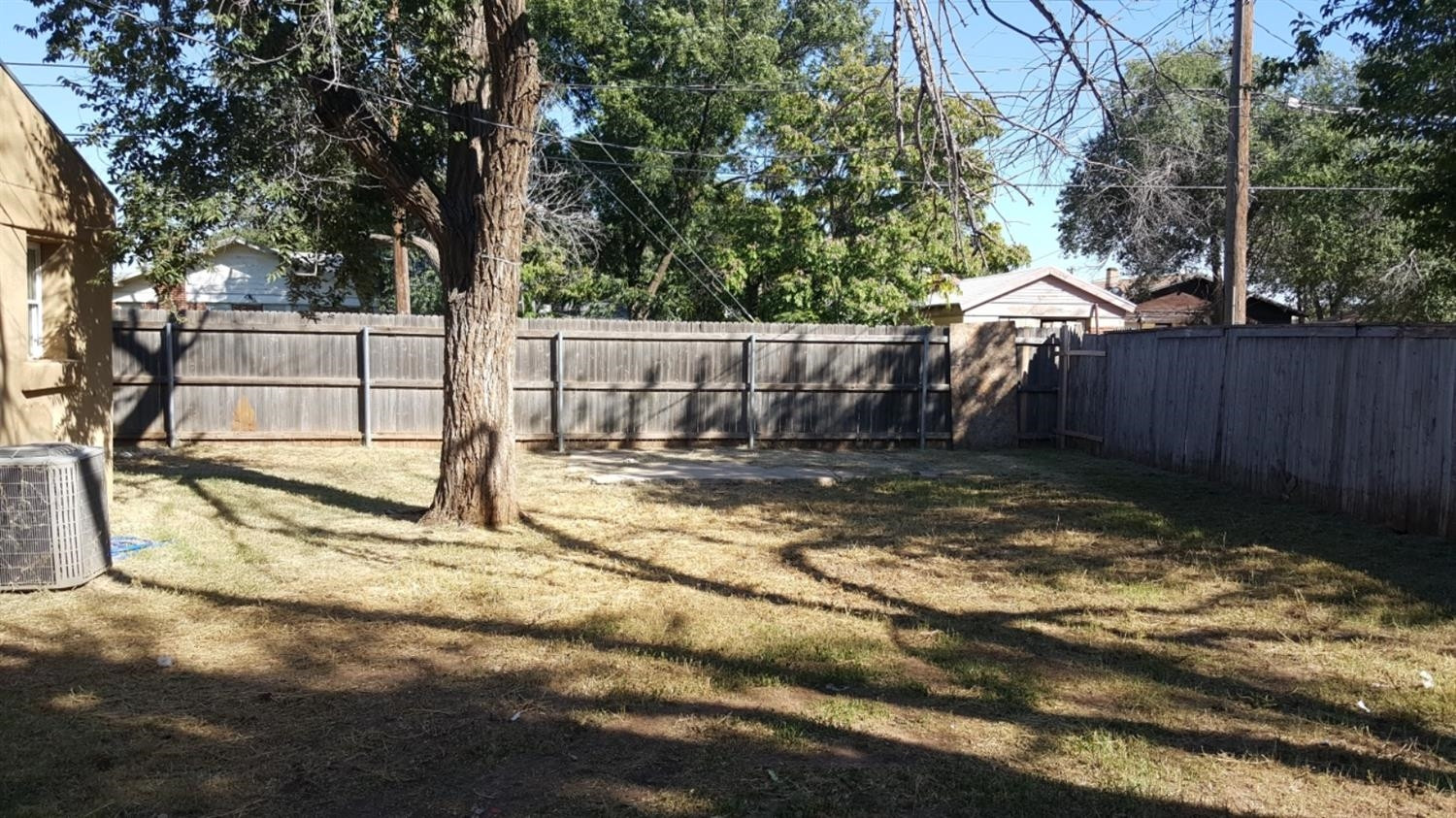 1807 18th Street Lubbock, TX 79401 - Photo 12 of 27 a view of backyard with small cabin and wooden fence
