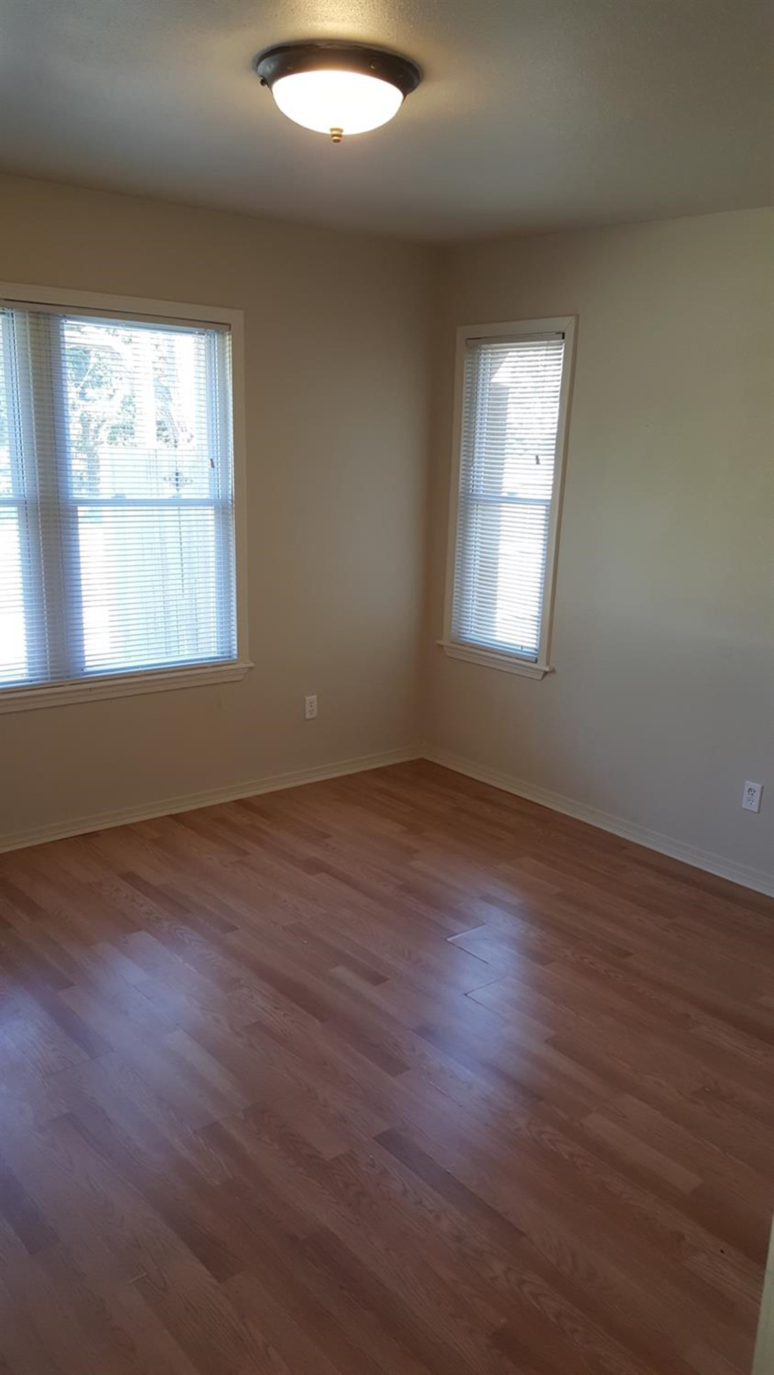 1807 18th Street Lubbock, TX 79401 - Photo 15 of 27 an empty room with wooden floor and windows