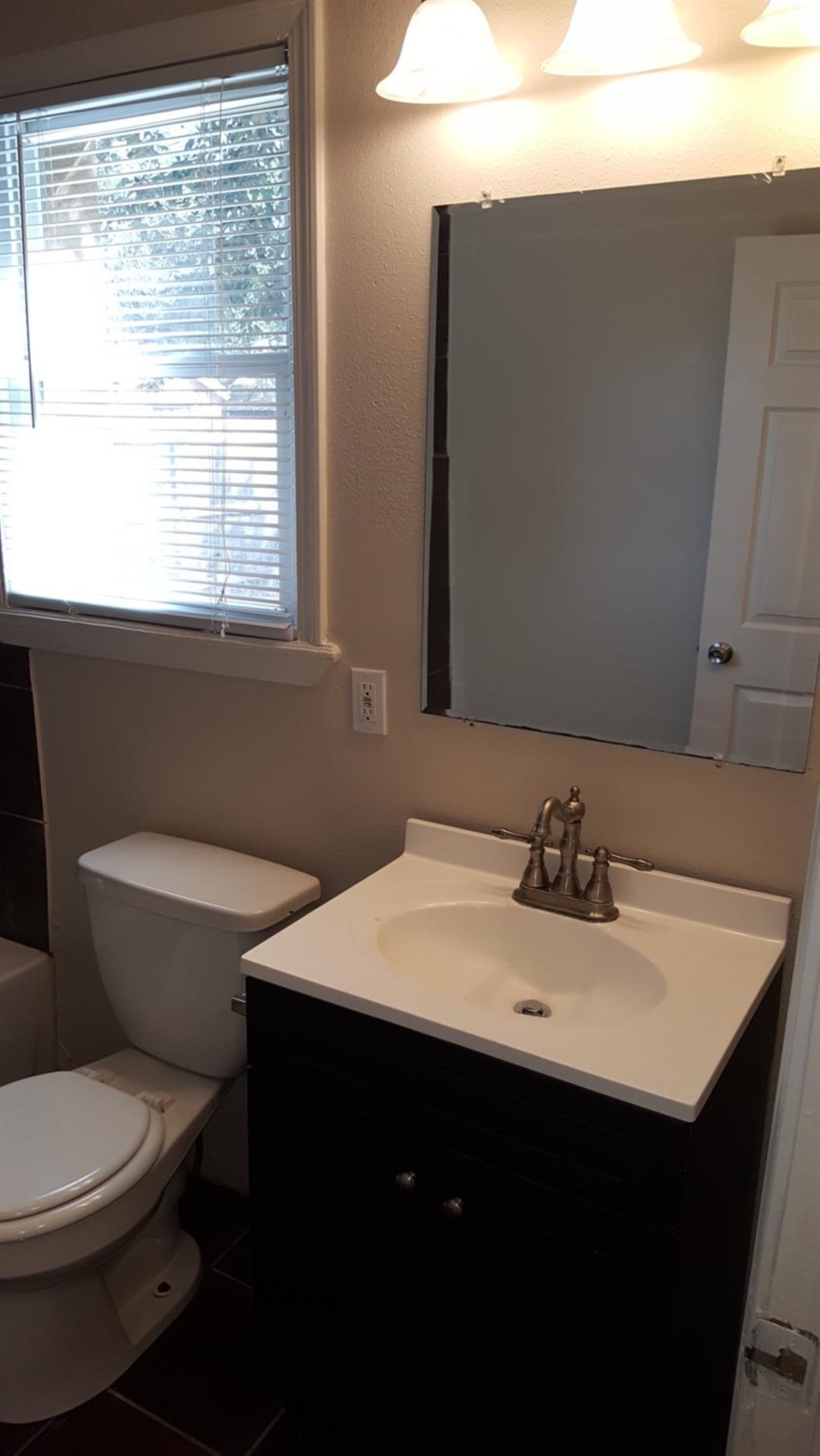 1807 18th Street Lubbock, TX 79401 - Photo 4 of 27 a bathroom with a sink vanity mirror and toilet