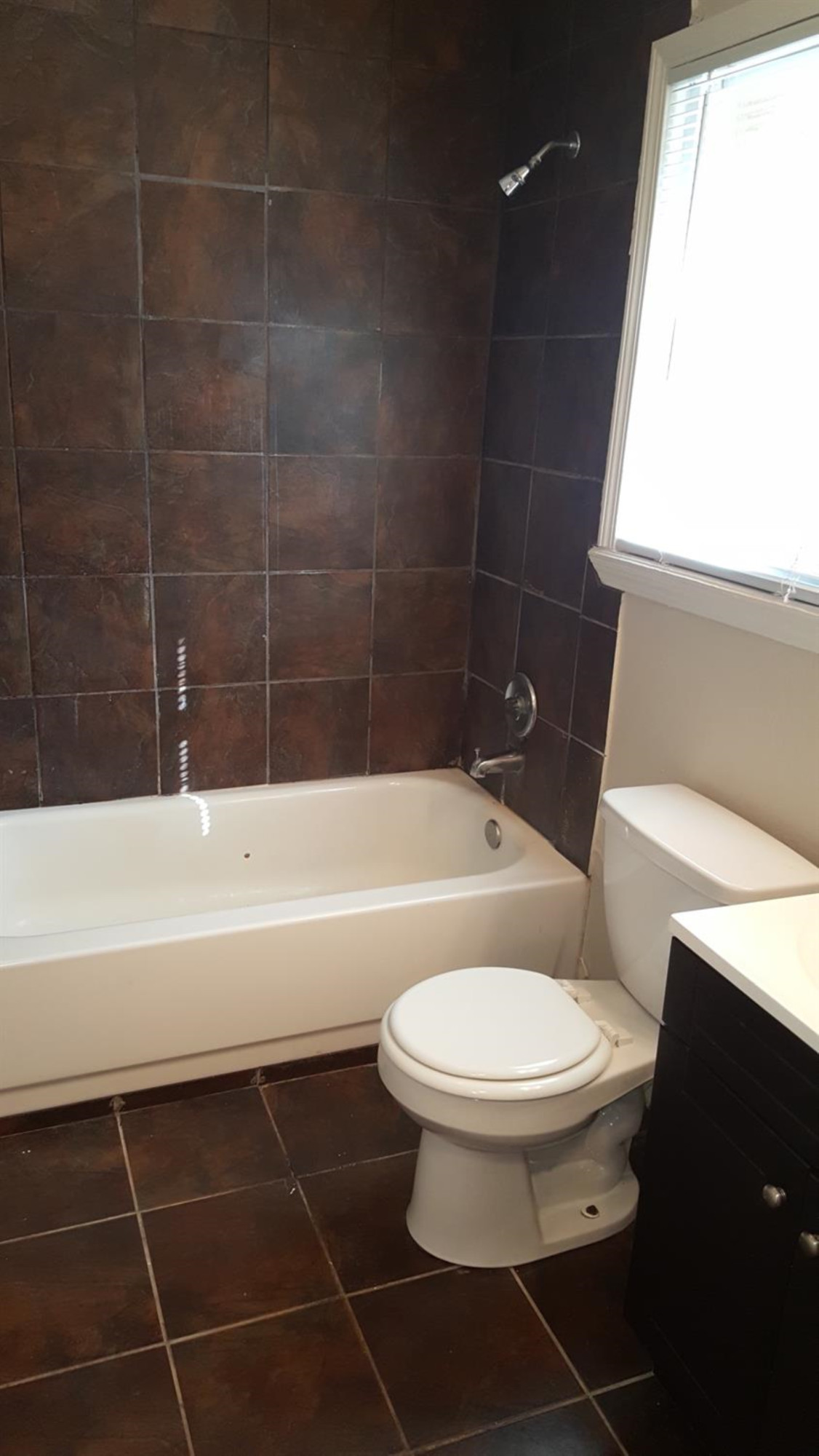 1807 18th Street Lubbock, TX 79401 - Photo 6 of 27 a bathroom with a toilet a sink and bathtub