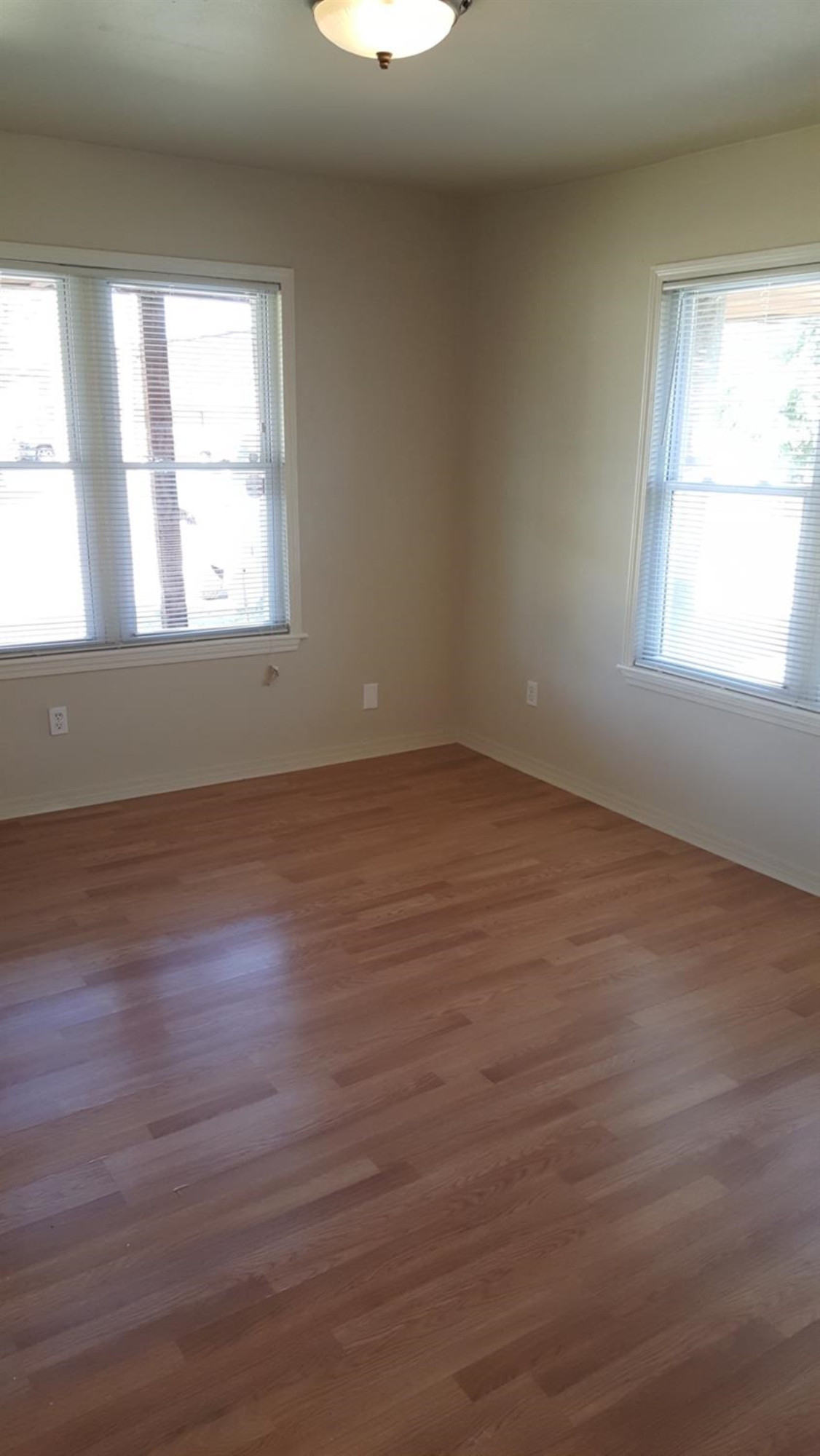 1807 18th Street Lubbock, TX 79401 - Photo 7 of 27 an empty room with wooden floor and windows