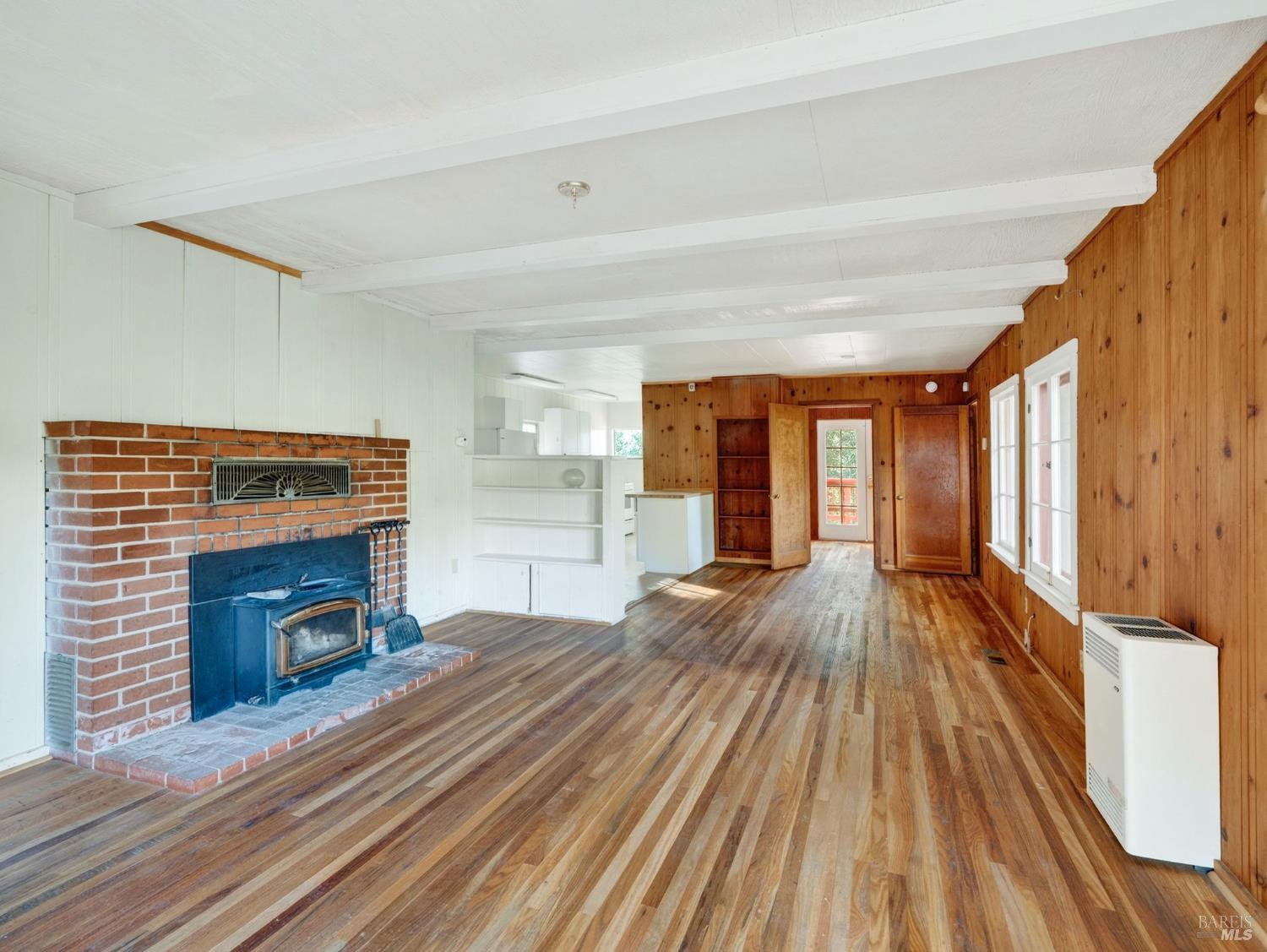 10701 Orr Springs Road Ukiah, CA 95482 - Photo 10 of 52 a view of an empty room with wooden floor fireplace and a window