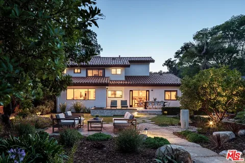 a front view of a house with outdoor seating and city view