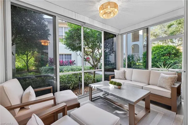 a living room with patio furniture and a floor to ceiling window