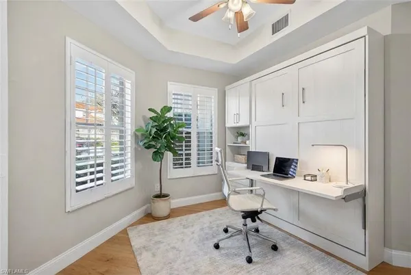 a view of a workspace with furniture and a window