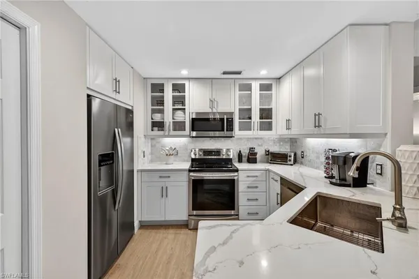 a kitchen with stainless steel appliances granite countertop a refrigerator stove and sink