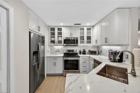 a kitchen with stainless steel appliances granite countertop a refrigerator stove and sink