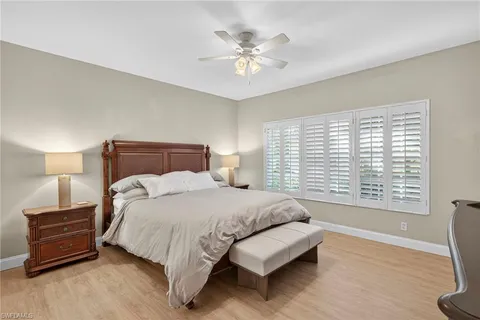 a bedroom with a bed a dresser and a chandelier