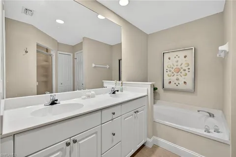 a bathroom with a tub sink and mirror