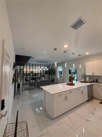 a kitchen with stainless steel appliances kitchen island granite countertop a table and chairs in it