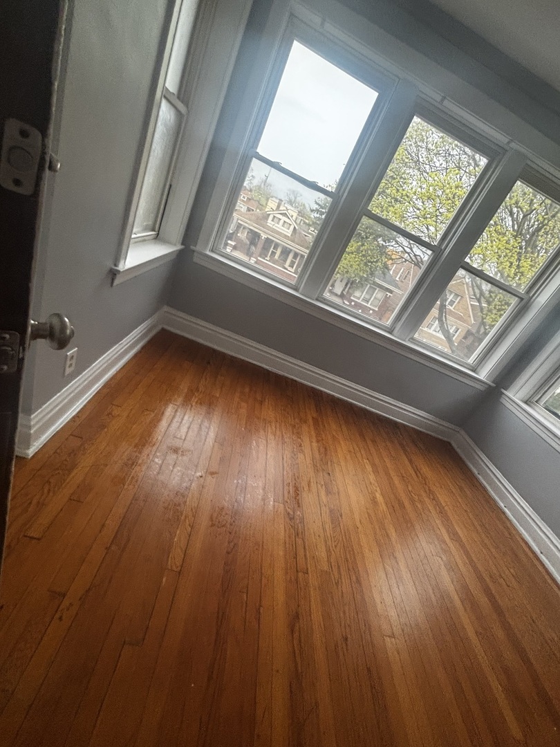 6546 South Rockwell Street, Unit 2 Chicago, IL 60629 - Photo 5 of 11 a view of an empty room with wooden floor and a window