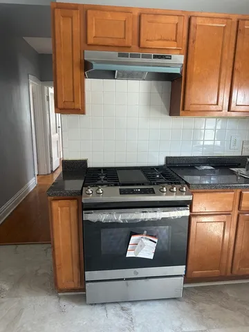 a stove top oven sitting inside of a kitchen