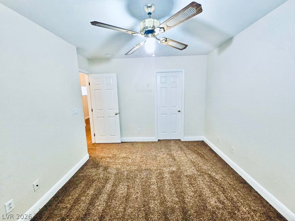 5953 Crumbling Ridge Street Henderson, NV 89011 - Photo 34 of 42 A comfortable bedroom with plush carpeting and a modern ceiling fan, offering a serene personal space.