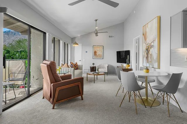 a living room with furniture a flat screen tv and a large window