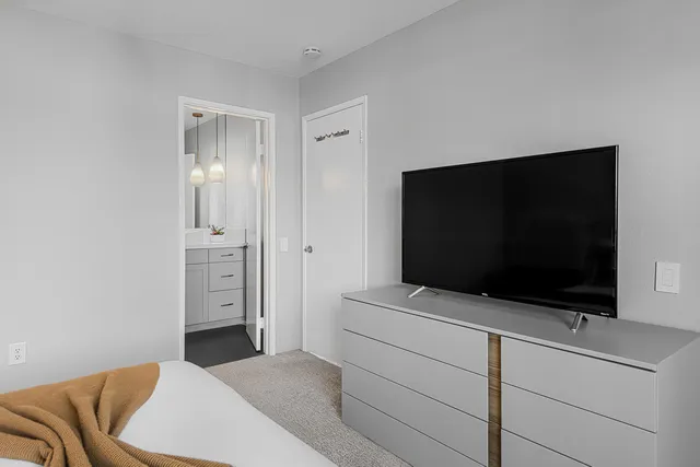 a bedroom with a bed and a flat screen tv