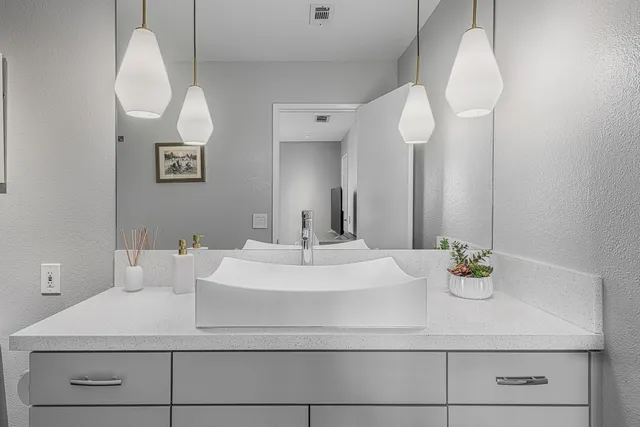 a bathroom with a sink a mirror and vanity