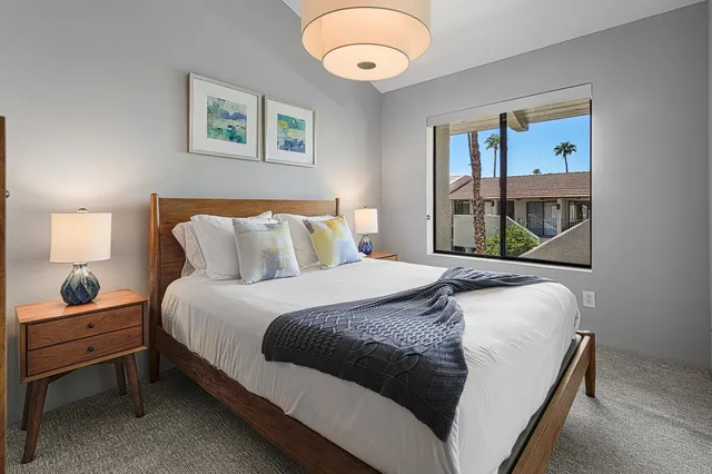 a bedroom with a bed and a painting on the wall