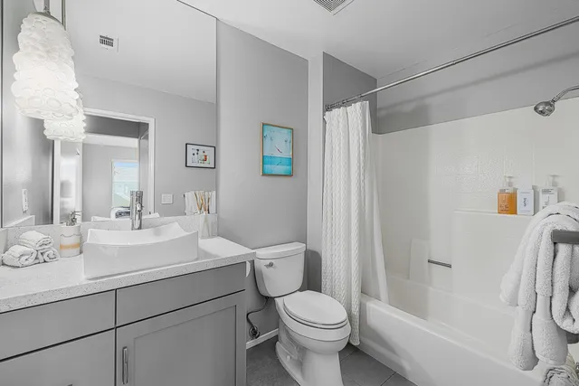 a bathroom with a sink toilet vanity and shower