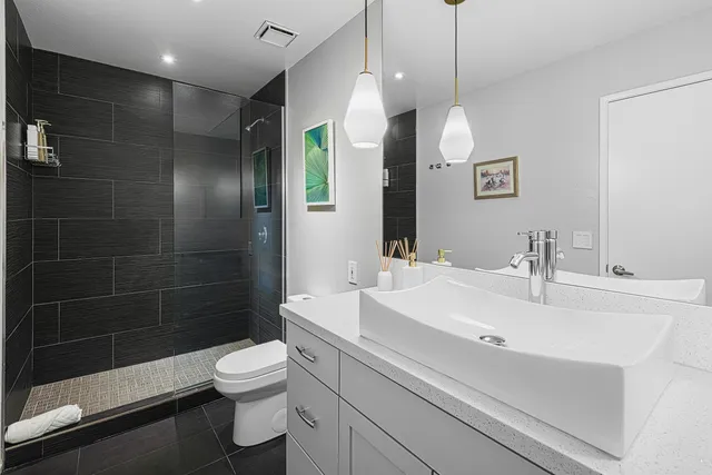 a bathroom with a sink a toilet and shower