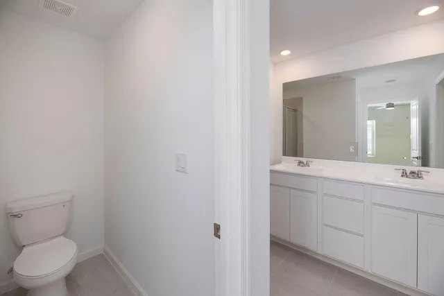 a bathroom with a toilet a sink and mirror