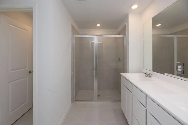 a bathroom with a sink shower and a mirror