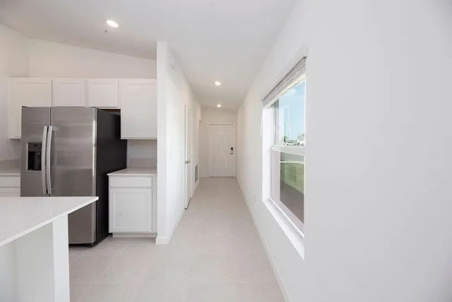 a view of a kitchen with a refrigerator and a sink