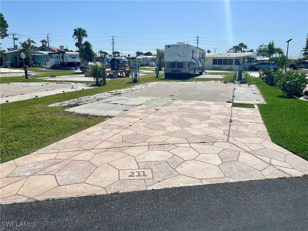 19681 Summerlin Road, Unit 211 Fort Myers, FL 33908 - Photo 2 of 21 a swimming pool with yard and view of houses