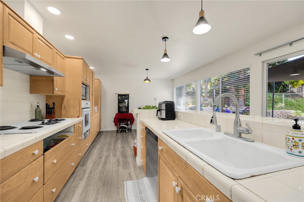 358 Lotus Place Brea, CA 92821 - Photo 8 of 31 a large kitchen with stainless steel appliances a stove a sink dishwasher and a refrigerator with wooden floor