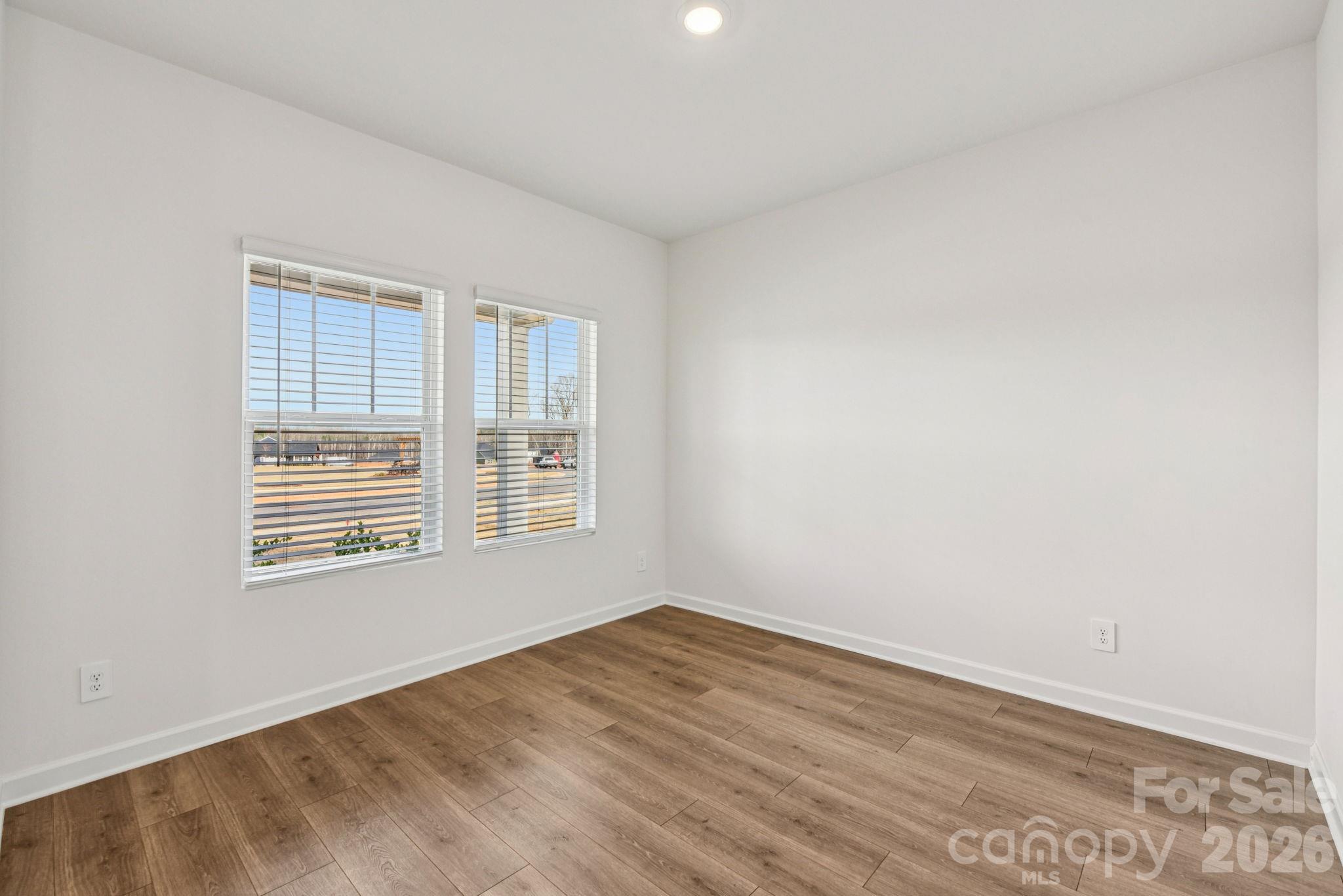 708 Palmer Pendleton Way York, SC 29745 - Photo 8 of 26 a view of an empty room with wooden floor and a window