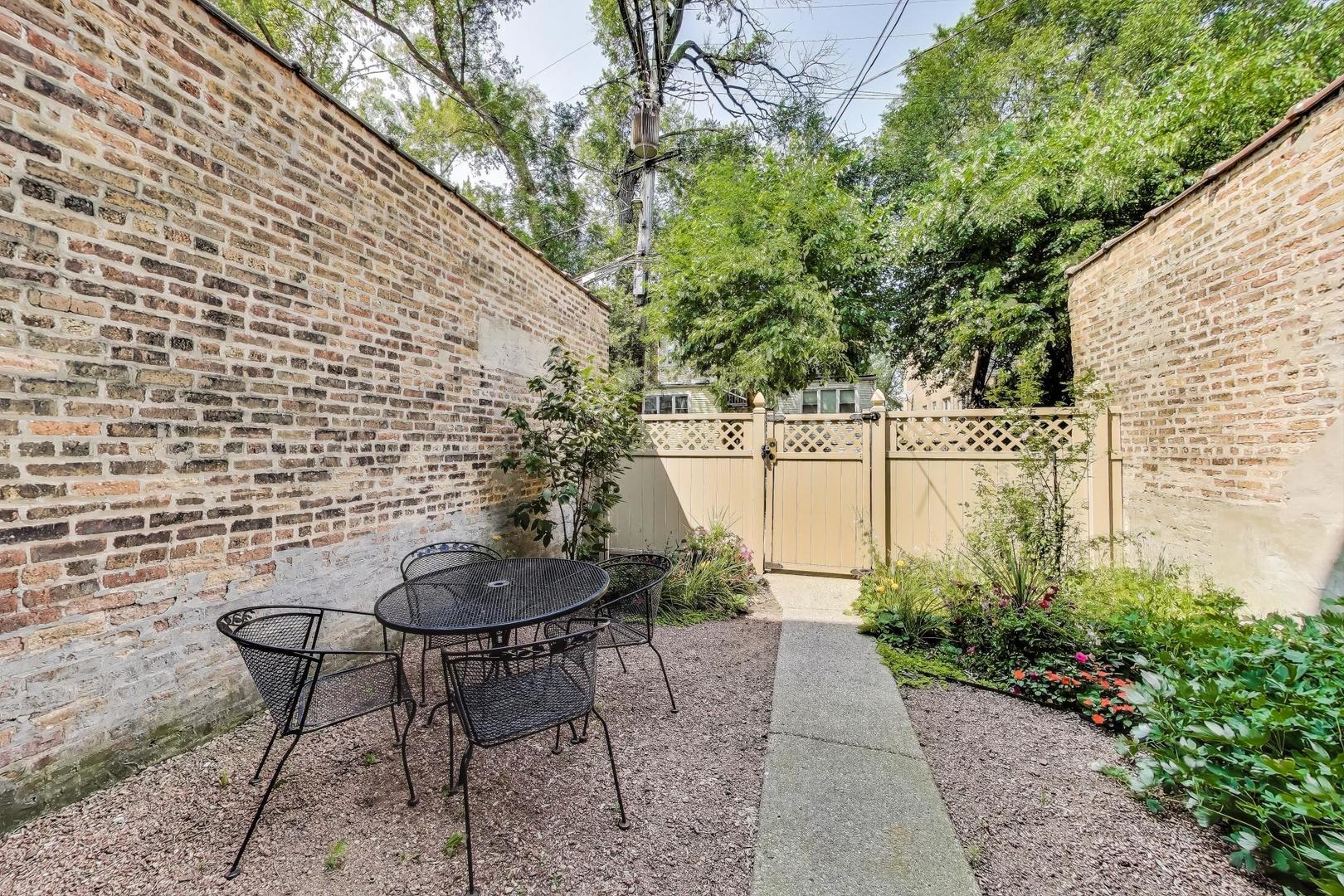 2322 West Farwell Avenue, Unit 1W Chicago, IL 60645 - Photo 26 of 28 a backyard of a house with table and chairs plants
