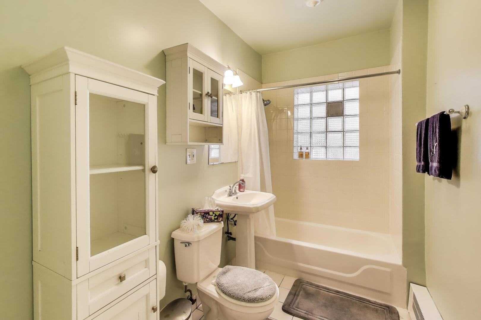 2322 West Farwell Avenue, Unit 1W Chicago, IL 60645 - Photo 10 of 28 a bathroom with a sink toilet and shower