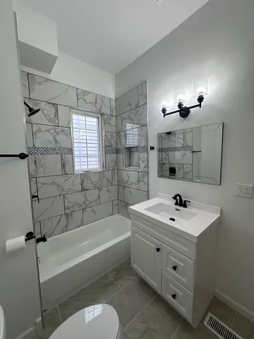 a bathroom with a sink a toilet and bathtub