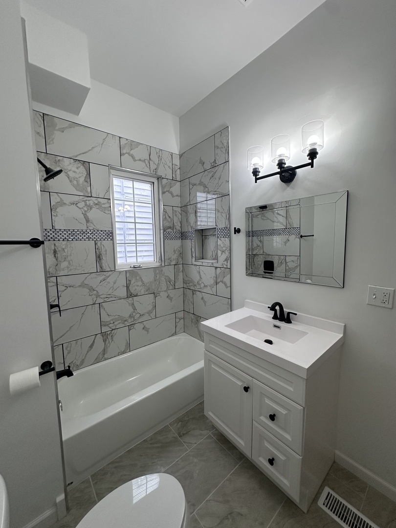 6715 South Sangamon Street Chicago, IL 60621 - Photo 15 of 43 a bathroom with a sink a toilet and bathtub