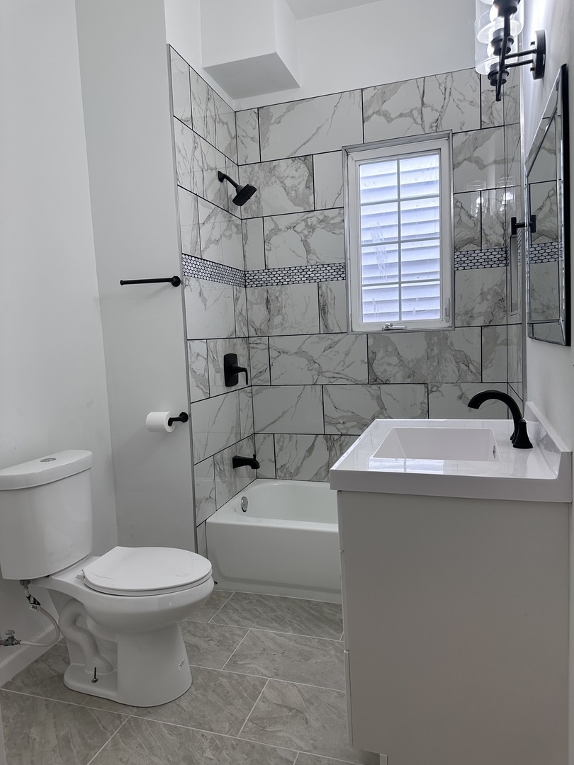 6715 South Sangamon Street Chicago, IL 60621 - Photo 16 of 43 a bathroom with a sink a toilet and shower