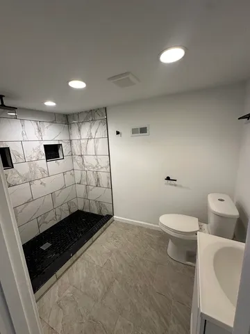 a bathroom with a sink a toilet and shower