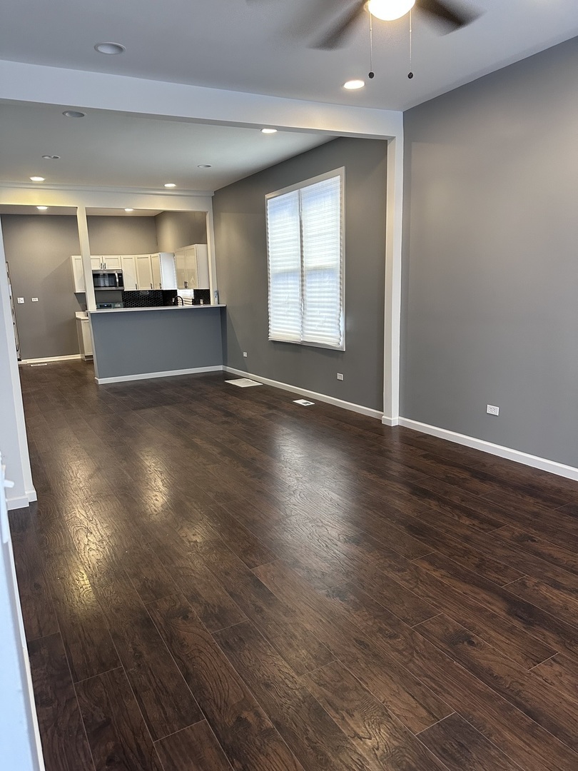 6715 South Sangamon Street Chicago, IL 60621 - Photo 4 of 43 an empty room with wooden floor and windows