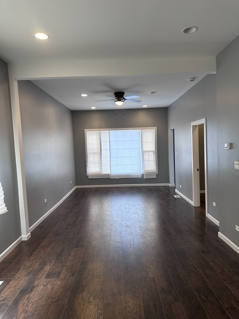 6715 South Sangamon Street Chicago, IL 60621 - Photo 5 of 43 an empty room with wooden floor and windows