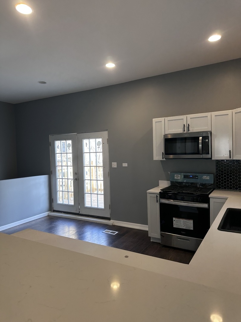 6715 South Sangamon Street Chicago, IL 60621 - Photo 7 of 43 a kitchen with granite countertop a stove and a refrigerator