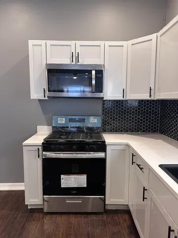 a stove top oven sitting inside of a kitchen
