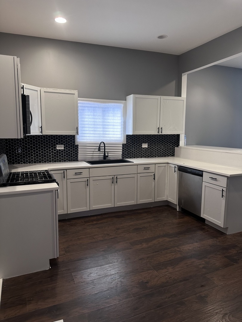 6715 South Sangamon Street Chicago, IL 60621 - Photo 10 of 43 a kitchen with a sink cabinets and wooden floor