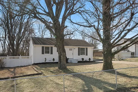 a white house that has a tree in front of it