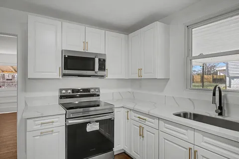 a kitchen with cabinets stainless steel appliances and a sink
