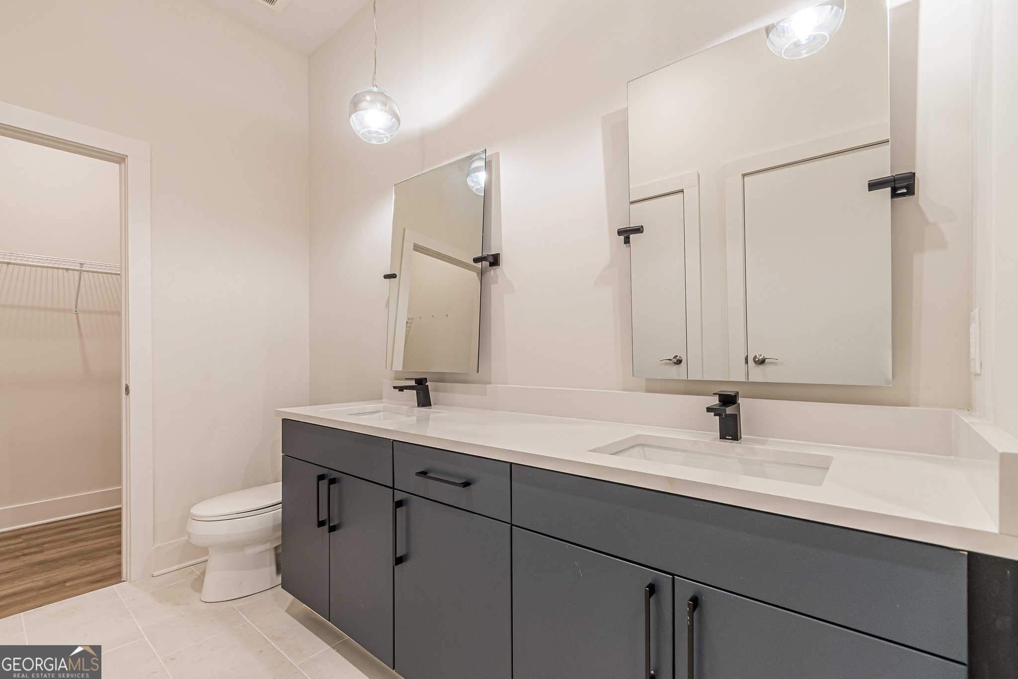112 Rogers Street Northeast, Unit 601 Atlanta, GA 30317 - Photo 11 of 31 a bathroom with a toilet a sink a mirror and a shower