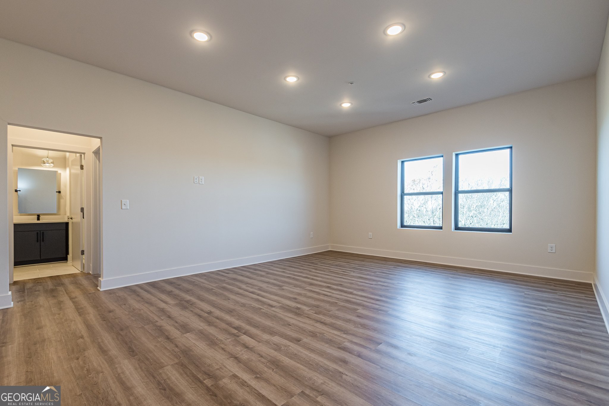 112 Rogers Street Northeast, Unit 601 Atlanta, GA 30317 - Photo 13 of 31 an empty room with wooden floor and windows